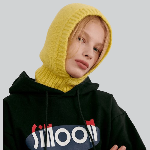 Person in bright yellow knitted balaclava hood and black hoodie with SMOOTH text