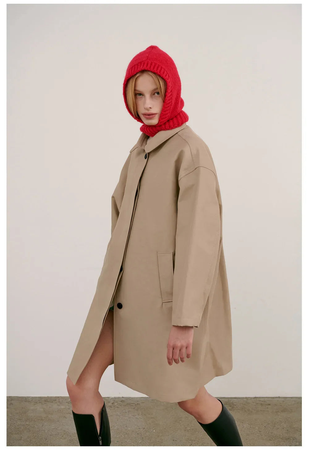 Beige oversized coat with bright red knitted hood balaclava and tall green boots