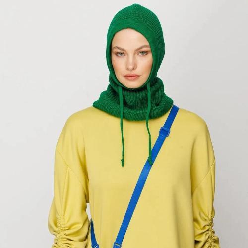 Woman in bright yellow sweater and green knit balaclava, Cape Coral style