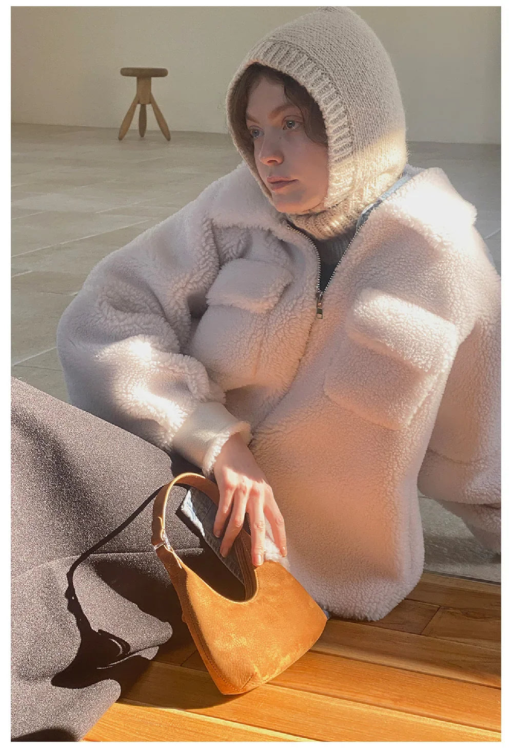 Woman in cozy white knit hat and oversized coat showcasing Wool Balaclava Knit