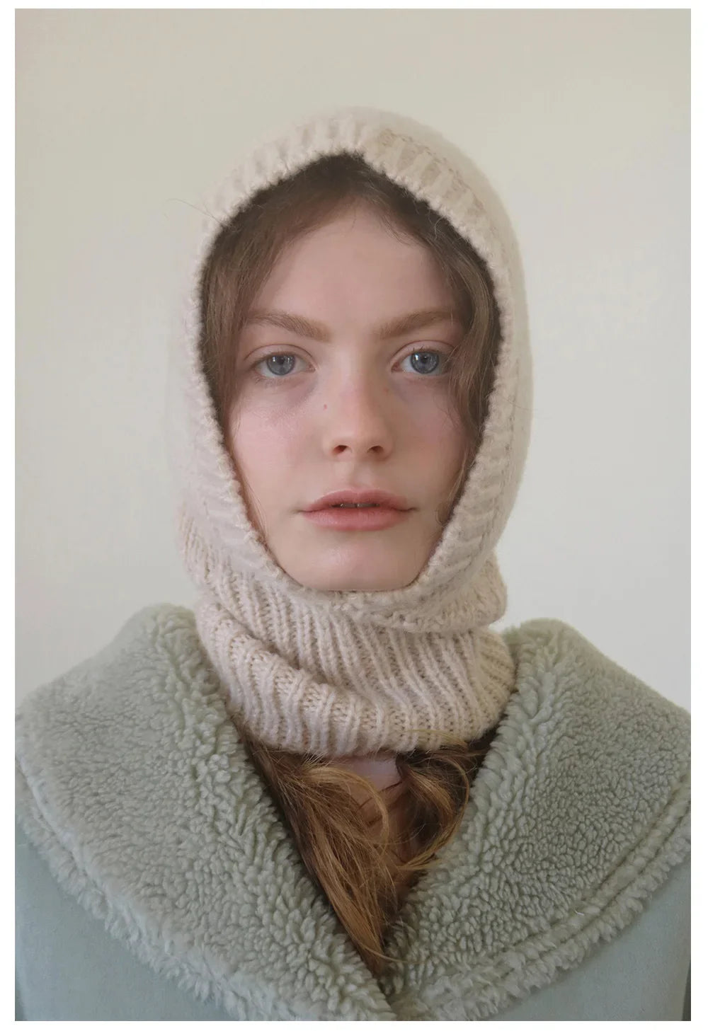 Person wearing a cream knit hood with a pale green collar from WOOL BALACLAVA KNIT