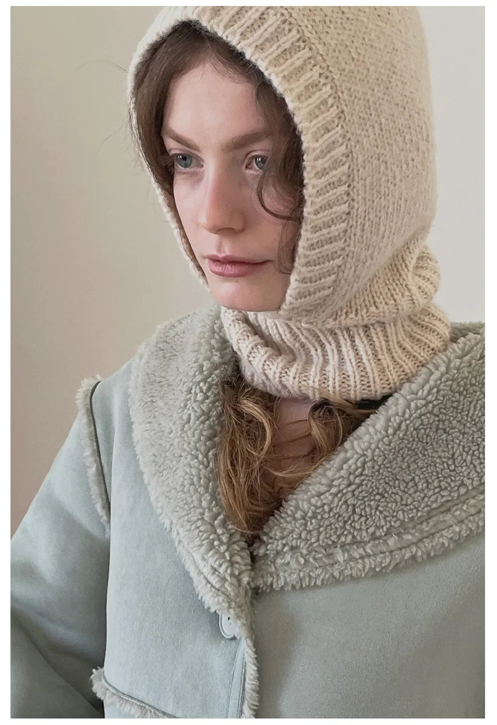 Knitted beige wool balaclava knit covering a person’s head and neck for warmth